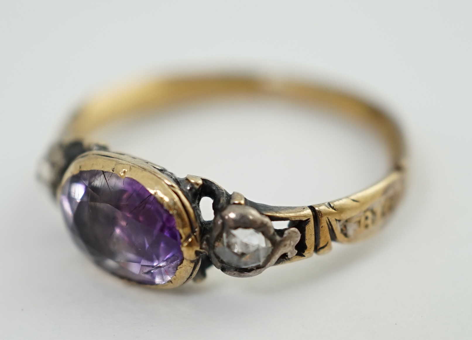 A George III gold, single stone foil backed amethyst and two stone rose cut diamond set memorial ring